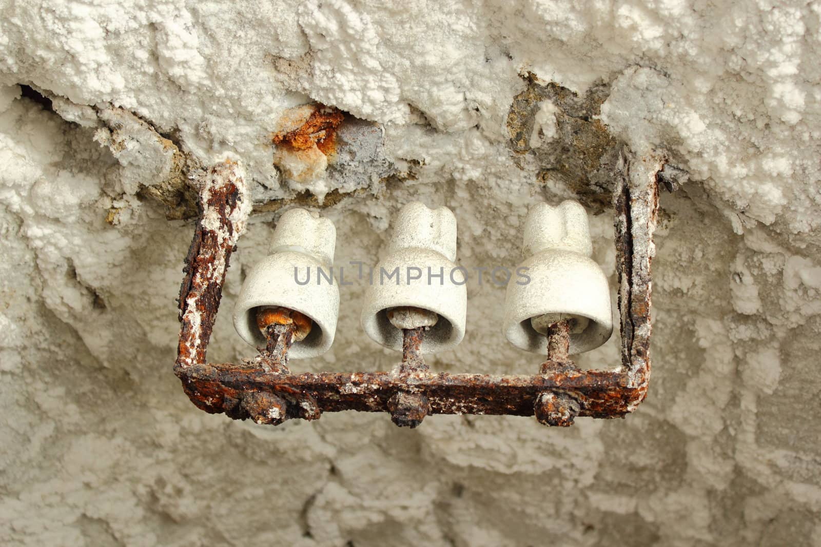 old electricity equipment in a salt mine ; the salt has drained off from the tunnel ceiling