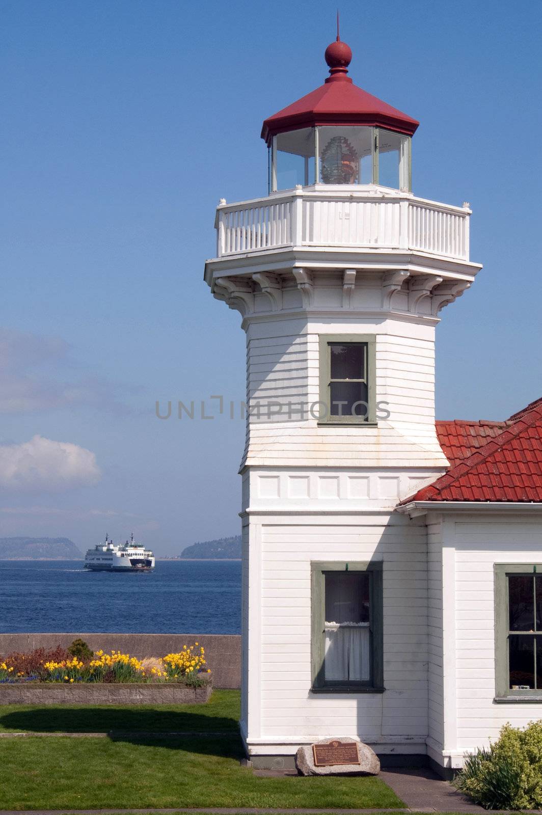 A ferry crosses the Puget Sound behind the Lighthouse