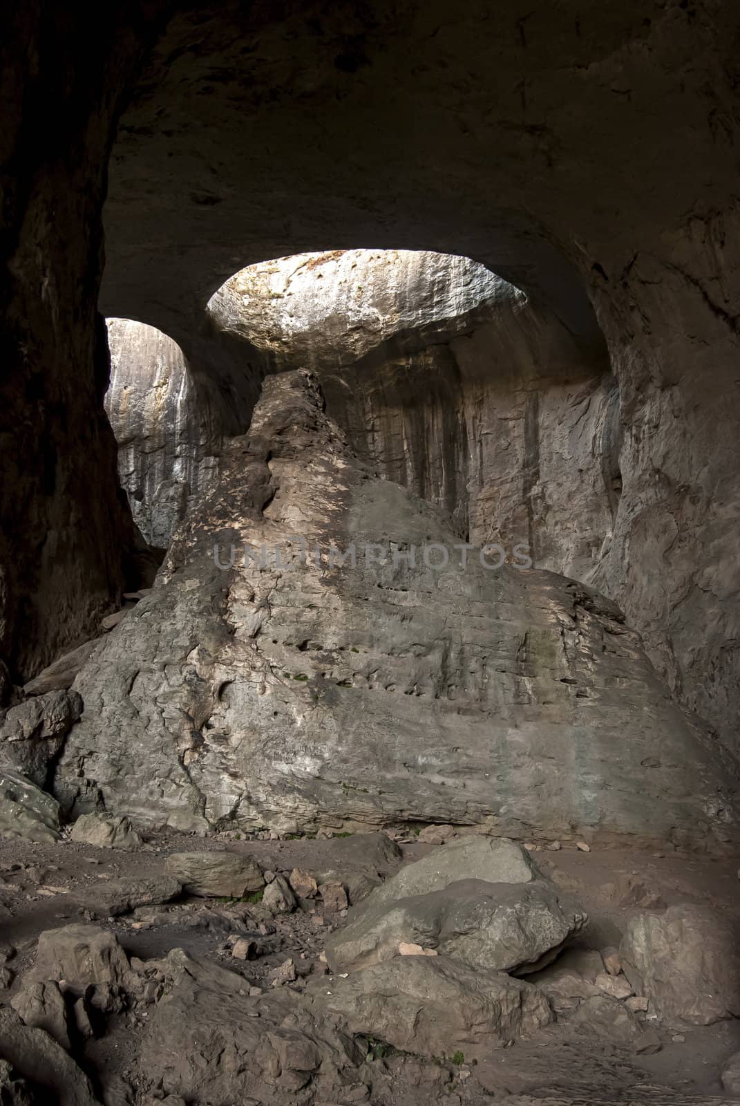 Cave inside with holes on ceiling by varbenov