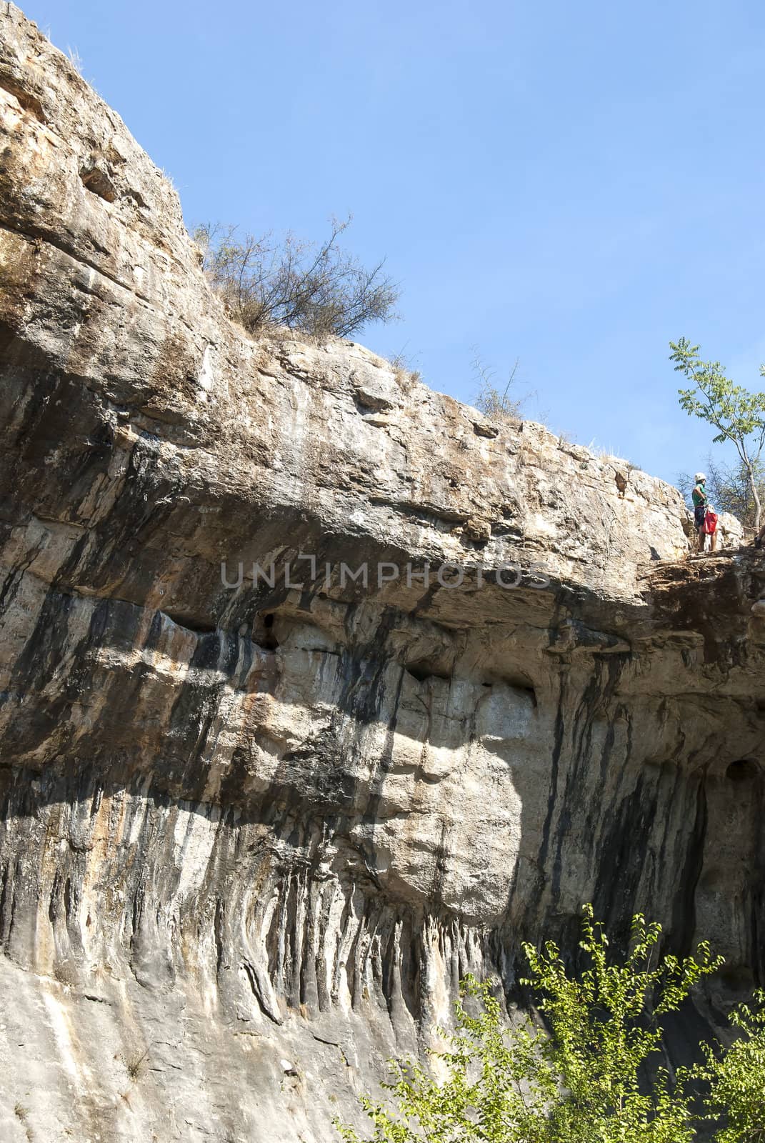 Rock landscape with climber on sky background