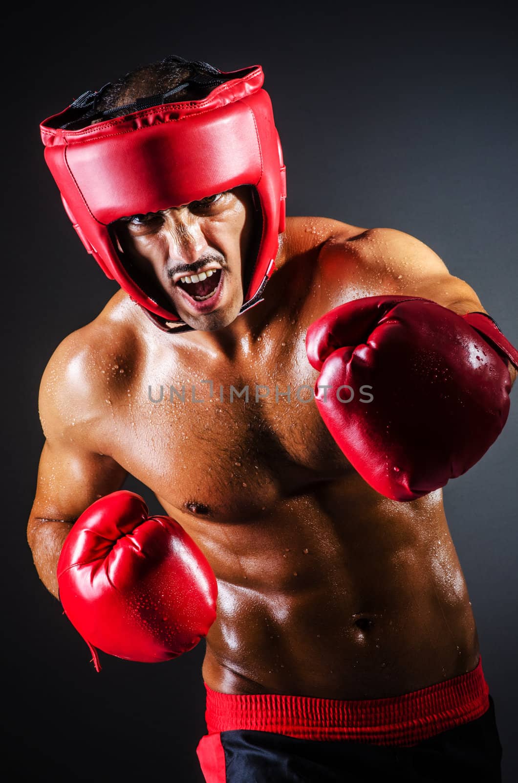 Boxer with red gloves in dark room