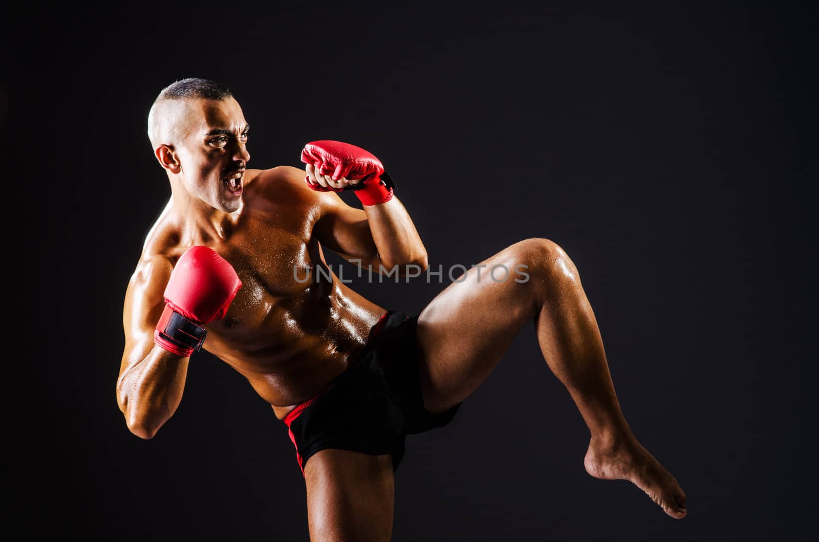 Boxer with red gloves in dark room