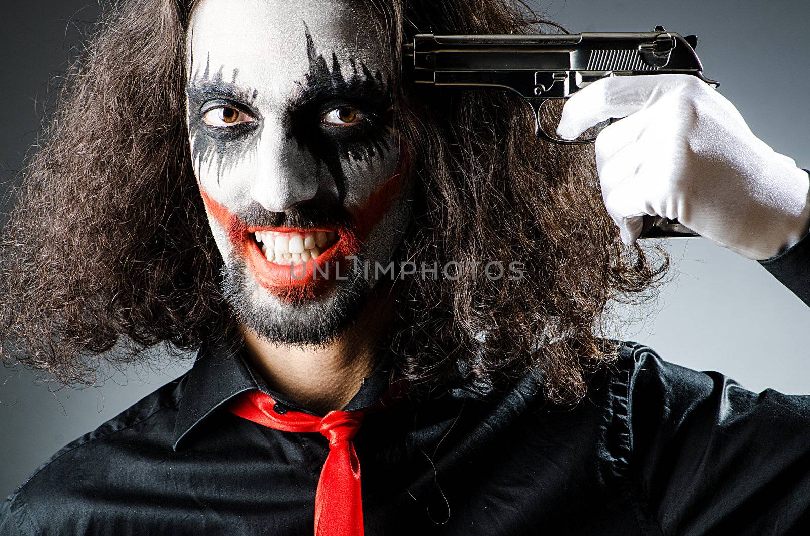 Evil clown with gun in dark room by Elnur