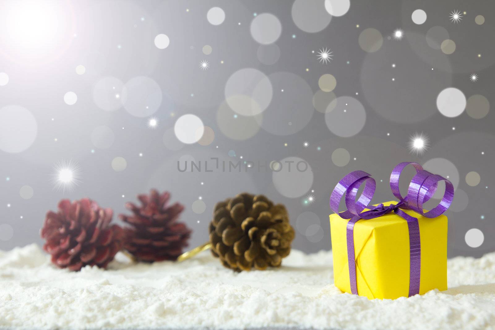 Christmas gift box on snow against defocused lights background