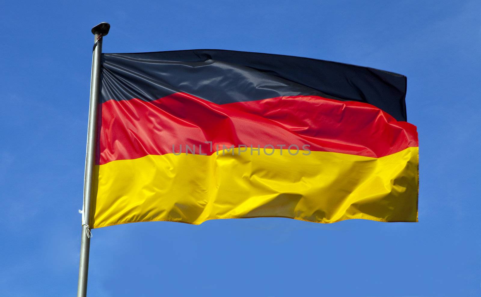 The German flag flying over a clear blue sky.