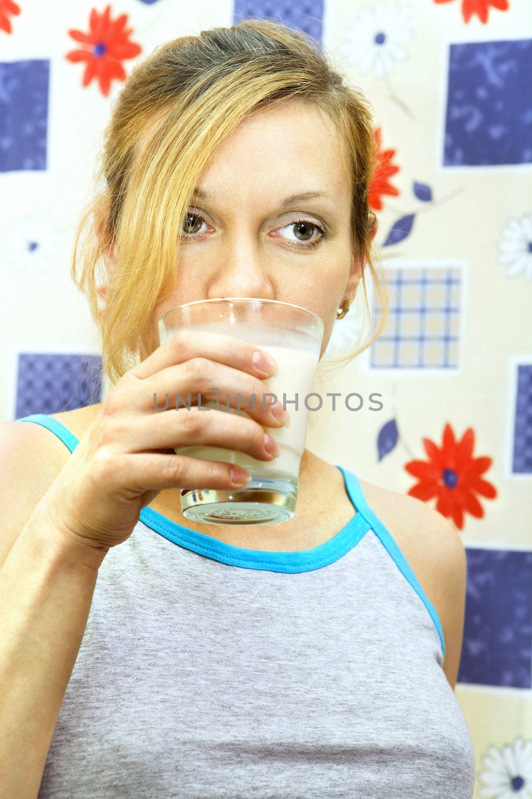 Portrait of sad young woman holding glass of milk