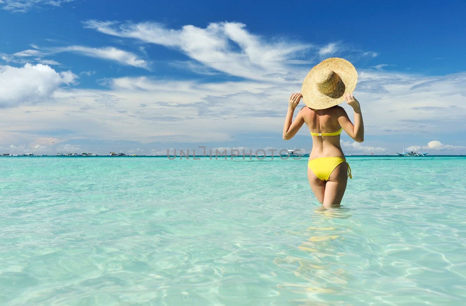 Girl on a tropical beach with outstretched arms