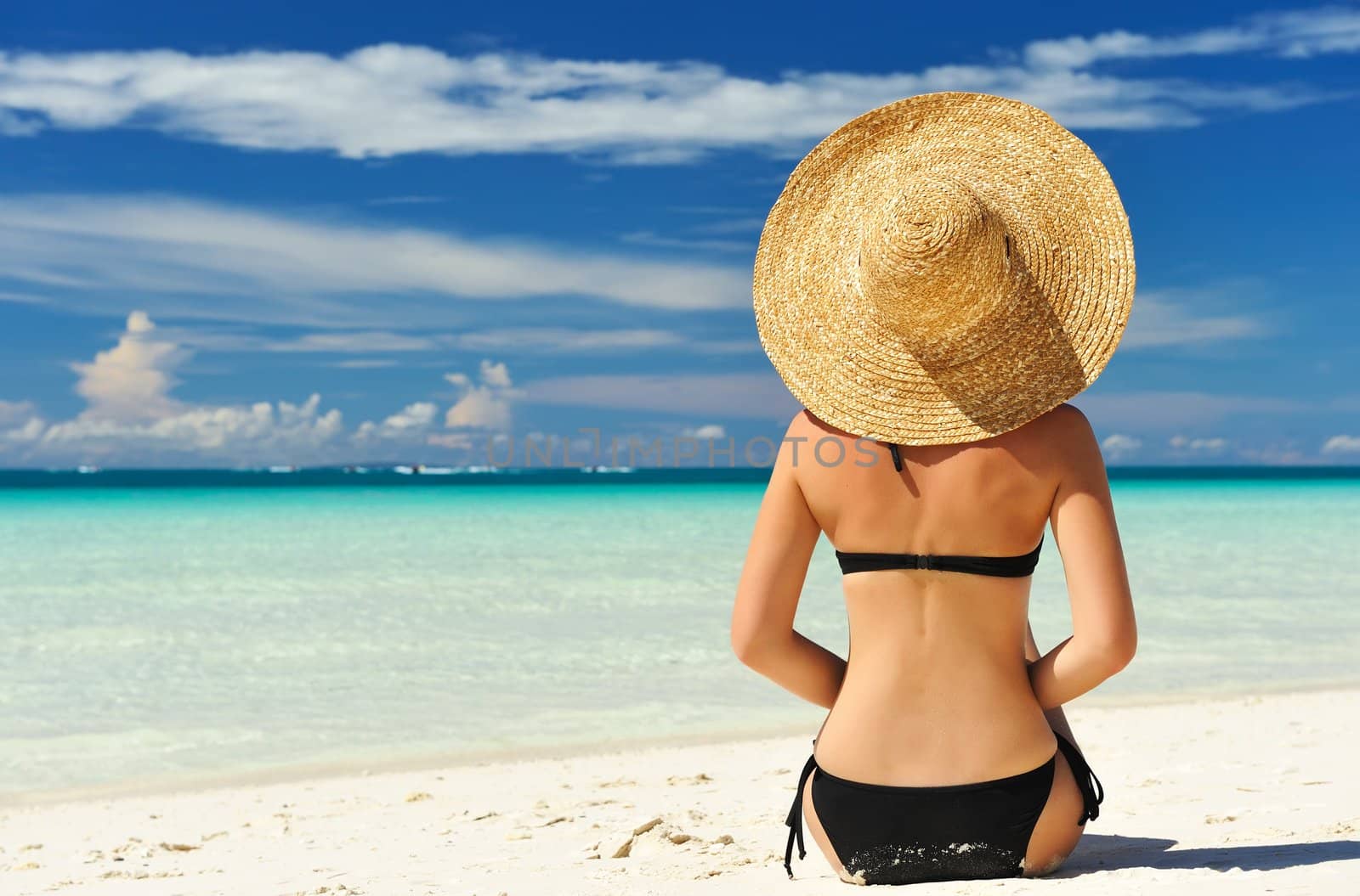 Girl on a tropical beach with hat