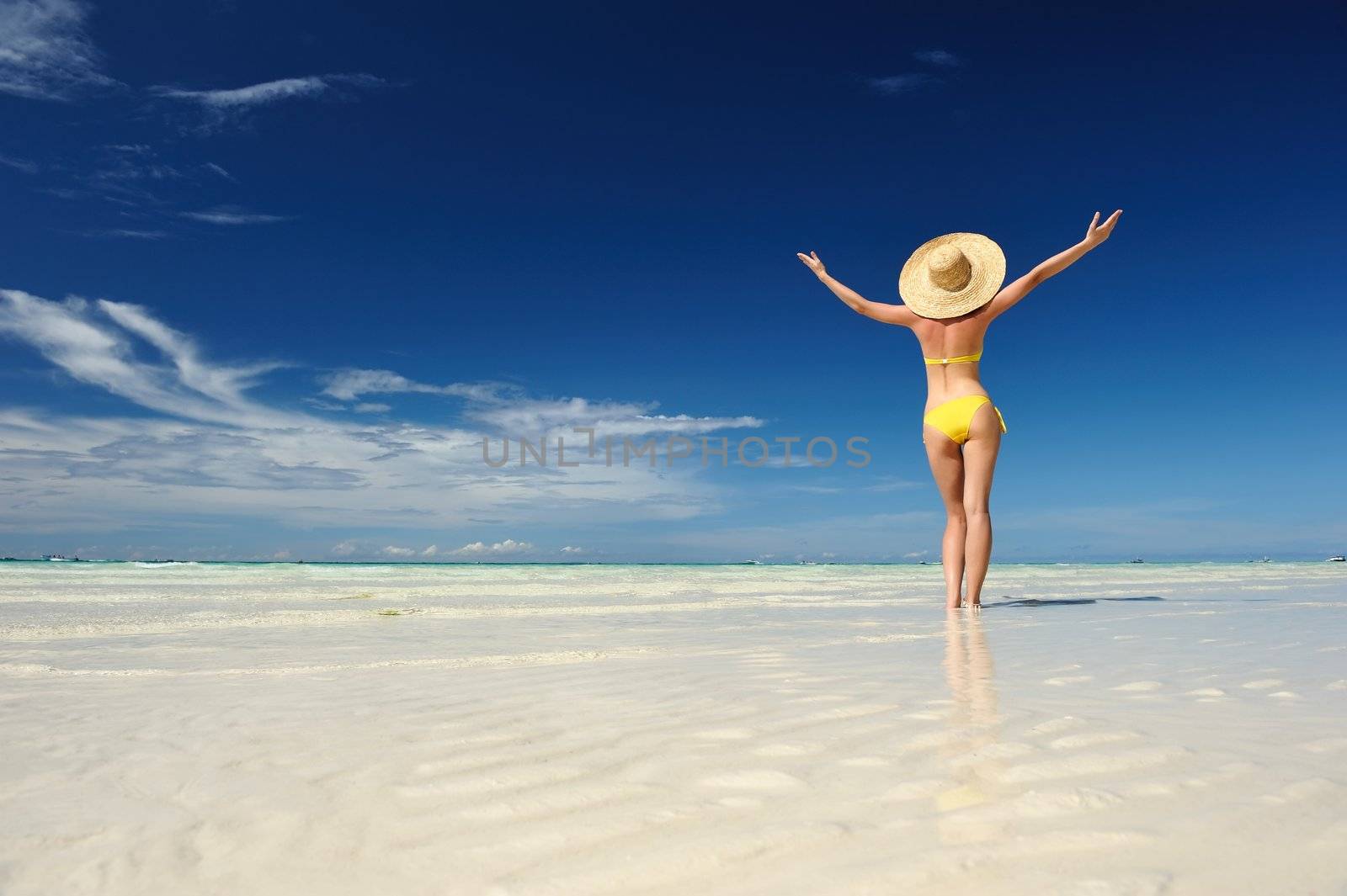 Girl on a tropical beach with outstretched arms