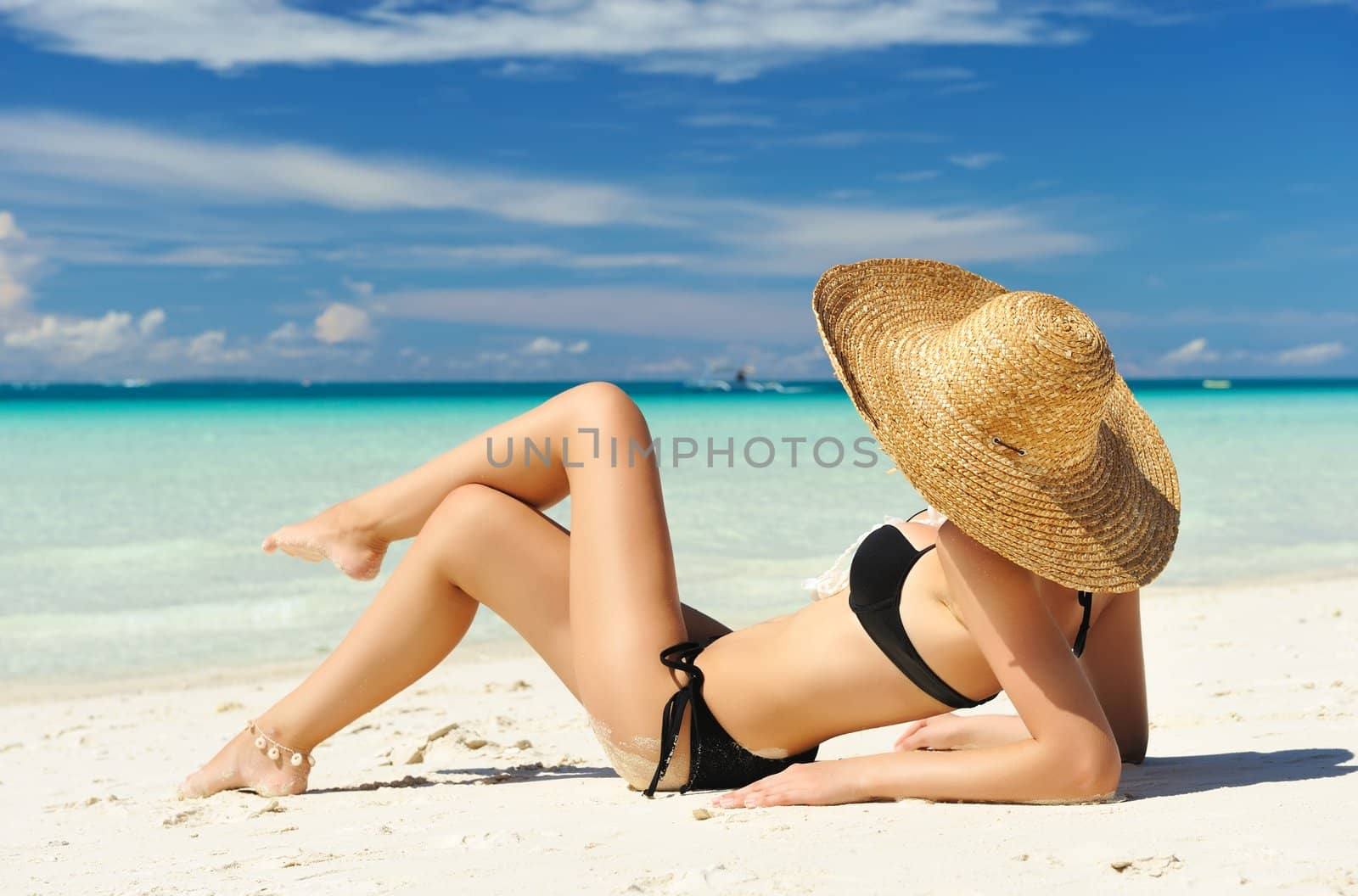 Girl on a tropical beach with hat