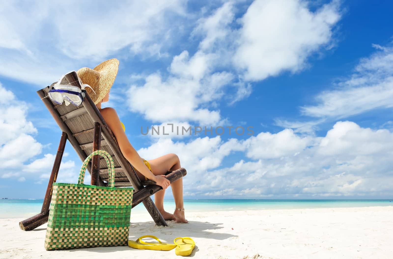 Girl on a tropical beach with hat