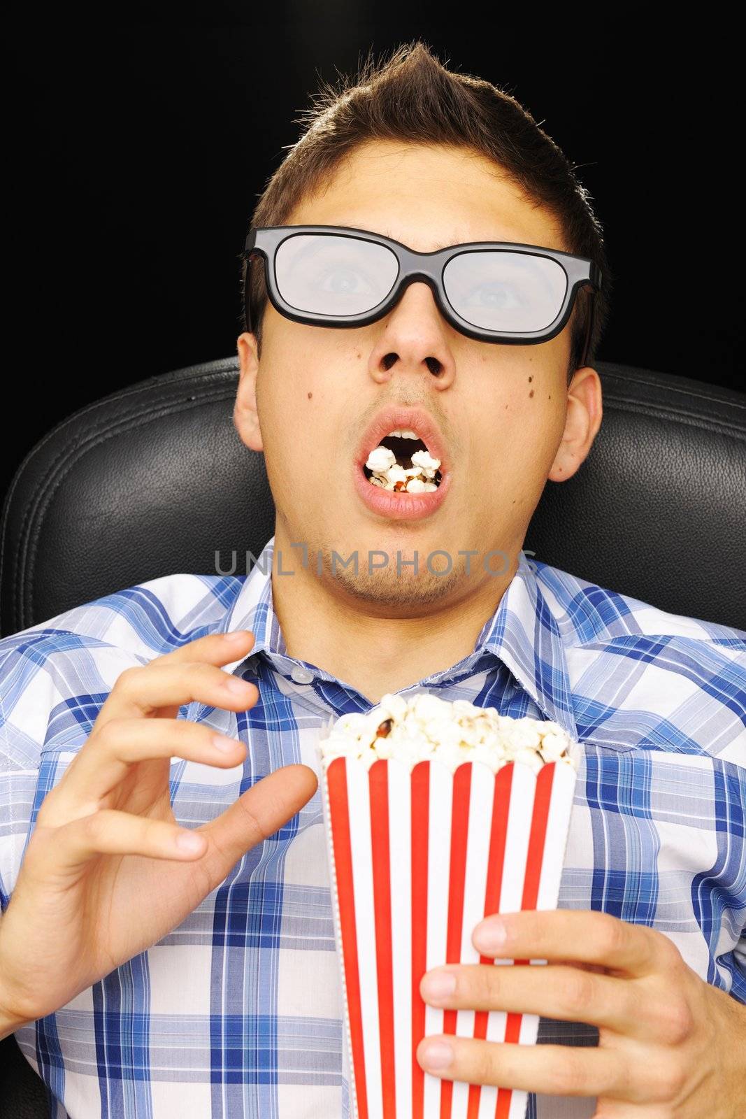 Young man watching movie in 3D glasses at cinema