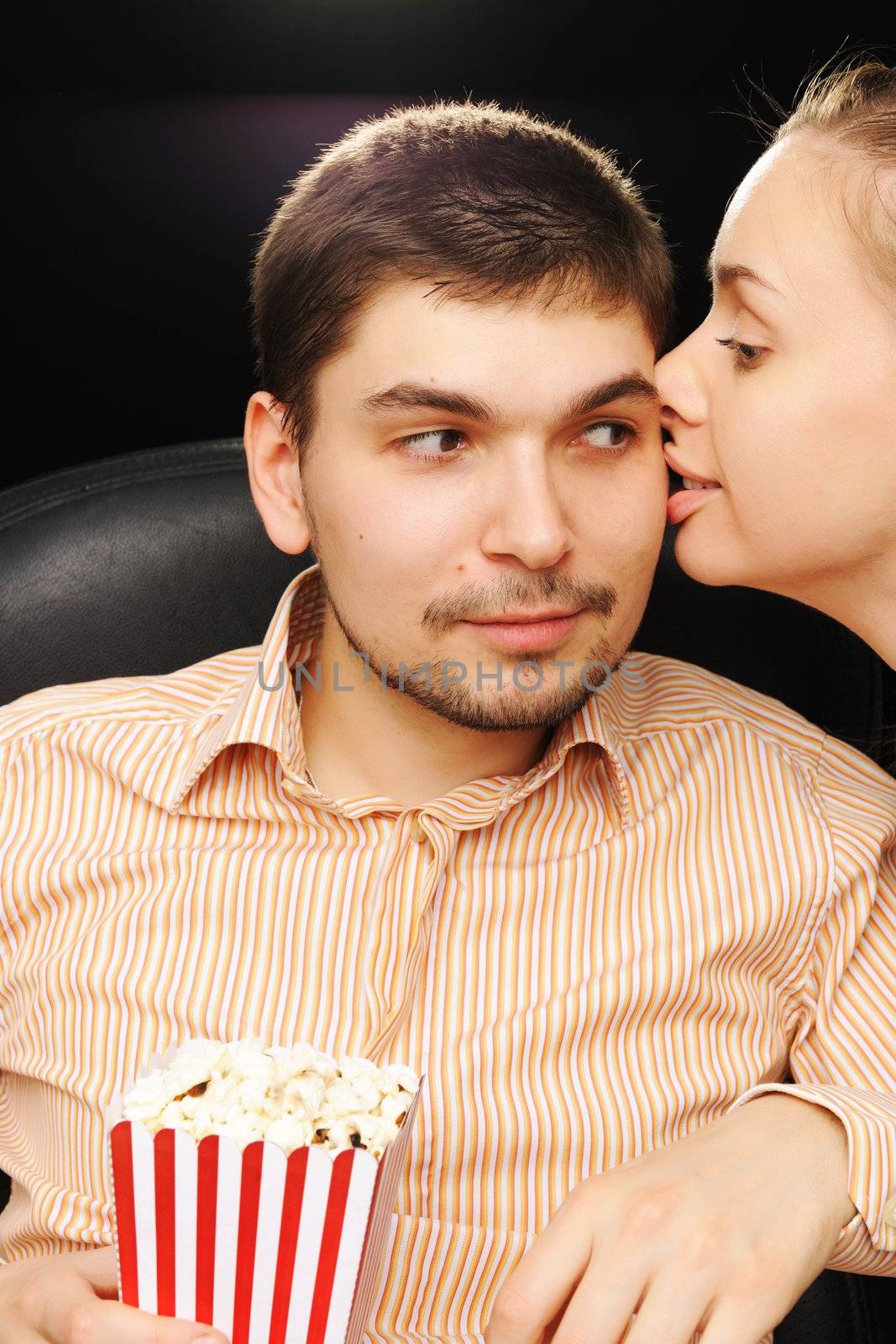 Young couple kissing at cinema