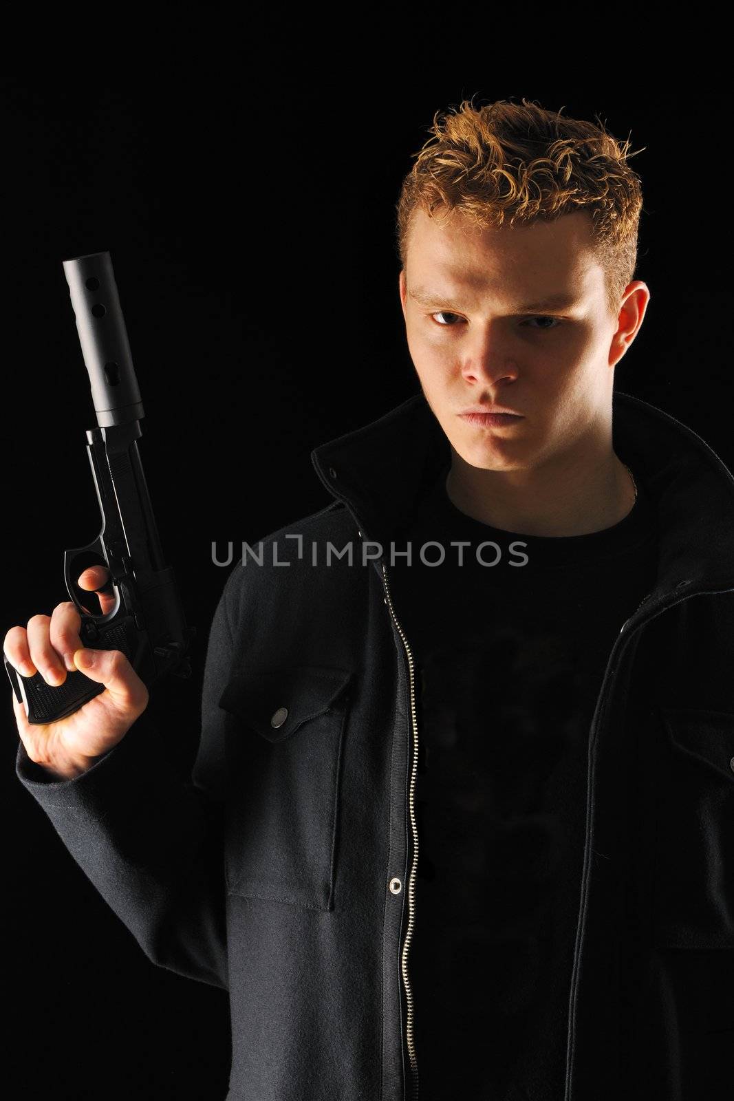 Man holding gun with silencer over black