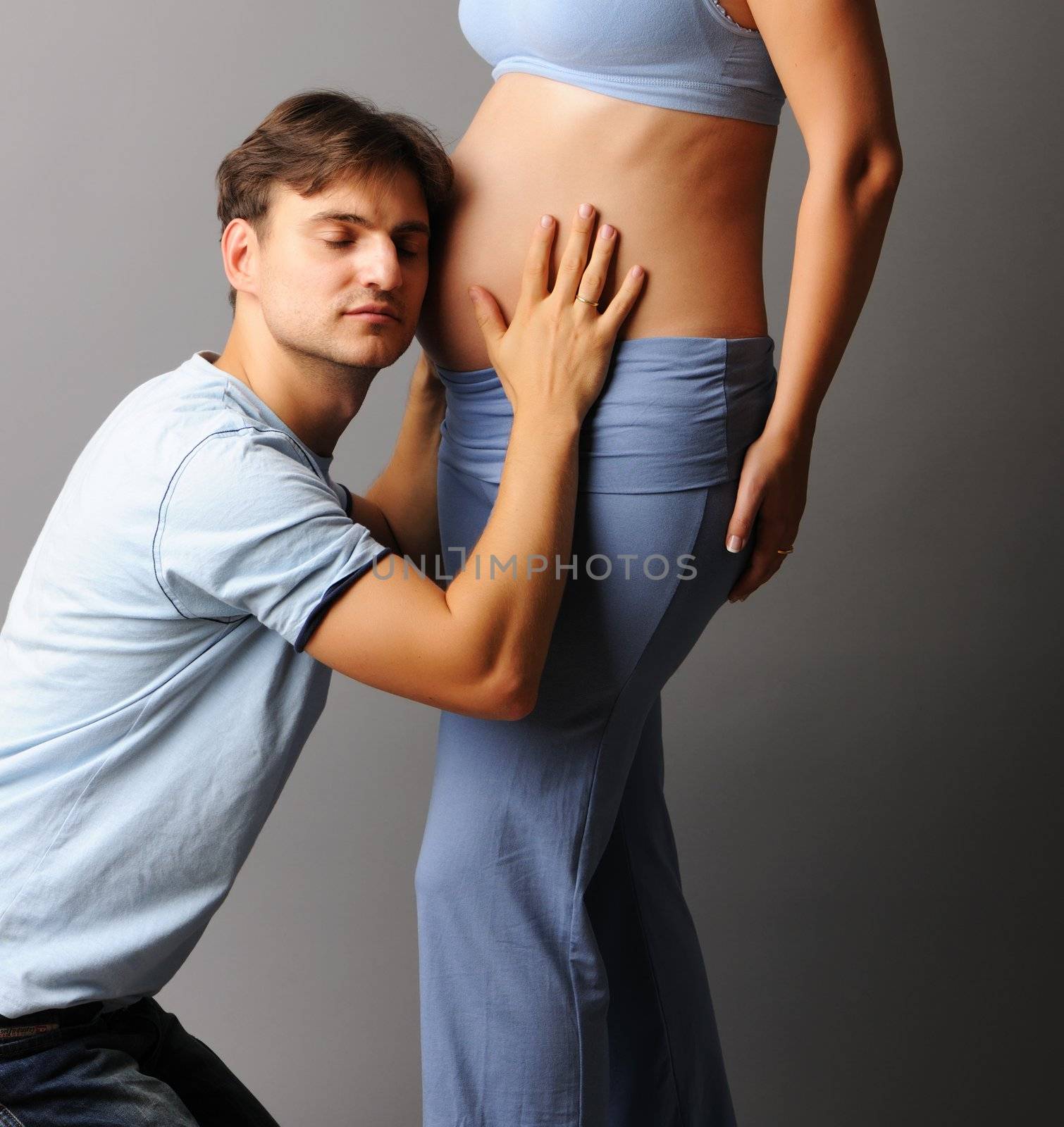 Happy pregnant couple over grey background