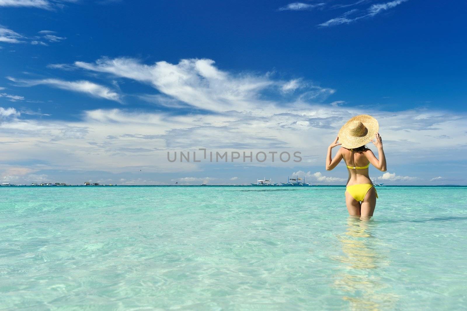 Girl on a tropical beach with hat