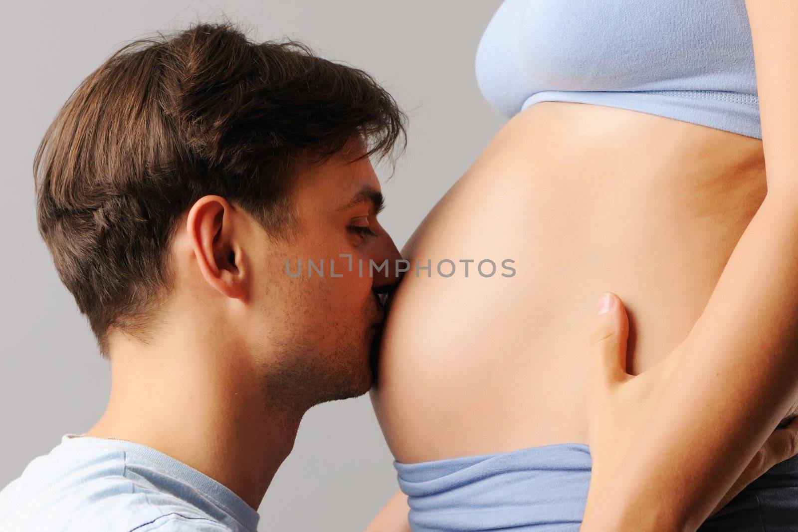 Happy father kissing his wife's belly