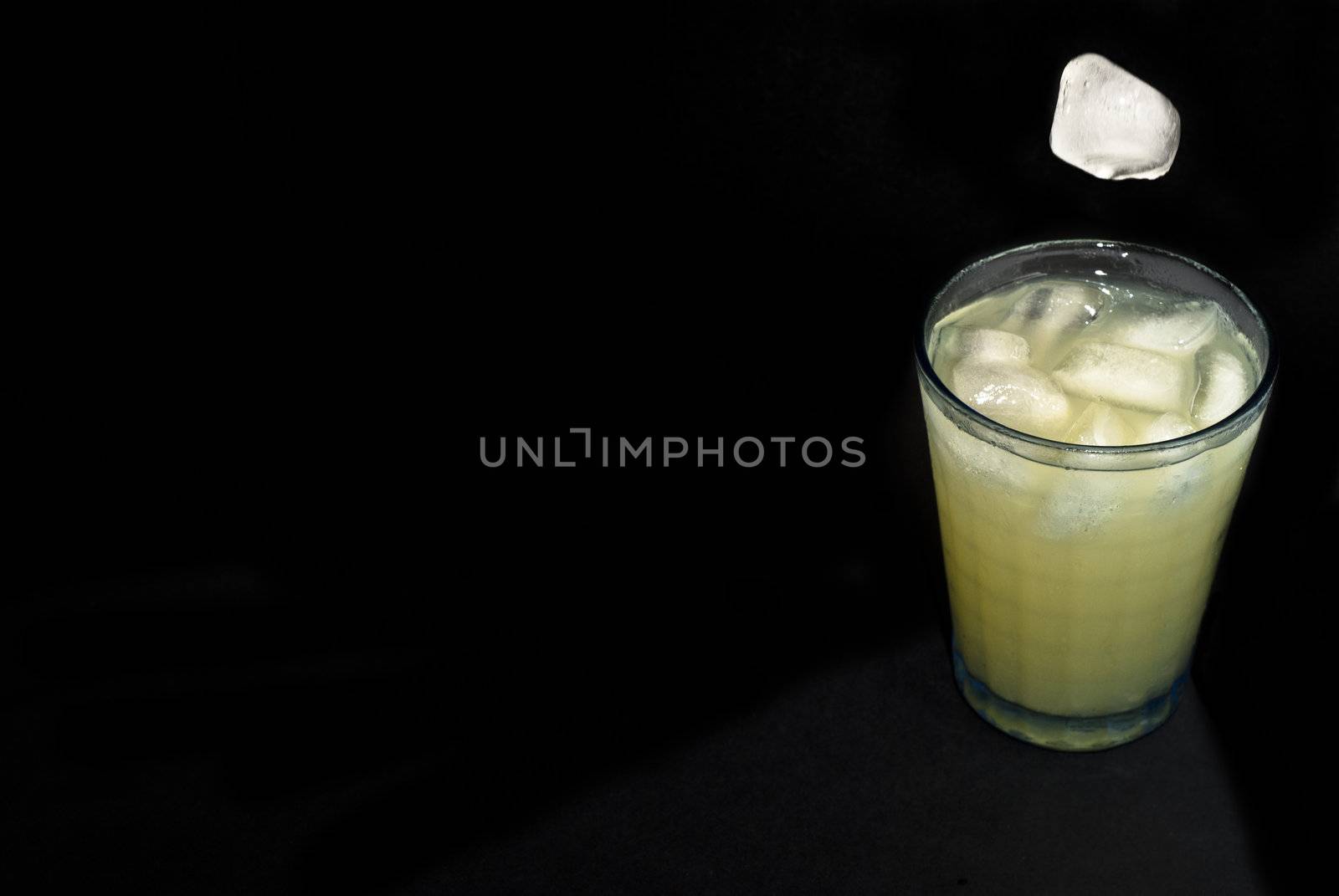 elegant cocktail glass with ice cube isolated on black  background