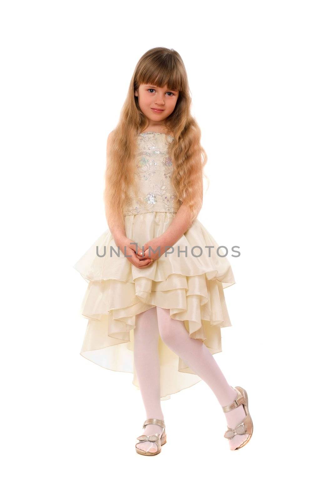 Cute little girl in a beige dress. Isolated
