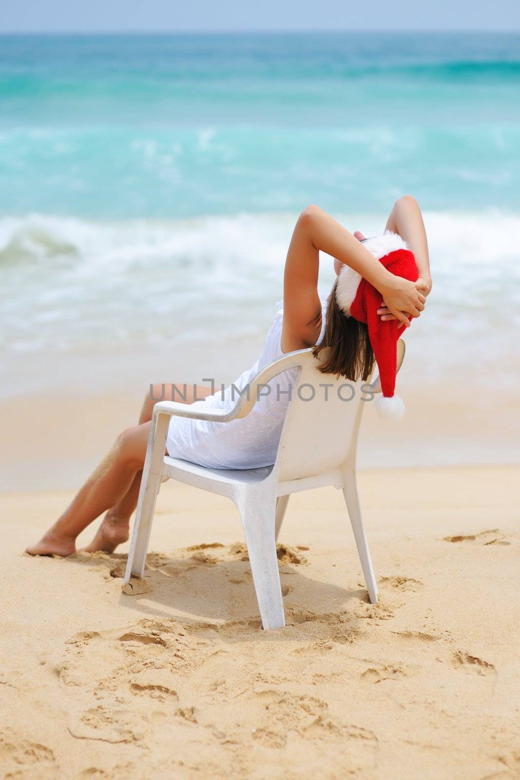 Woman on the beach in santa's hat