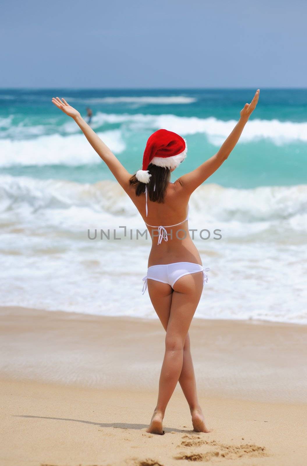 Woman on the beach in santa's hat