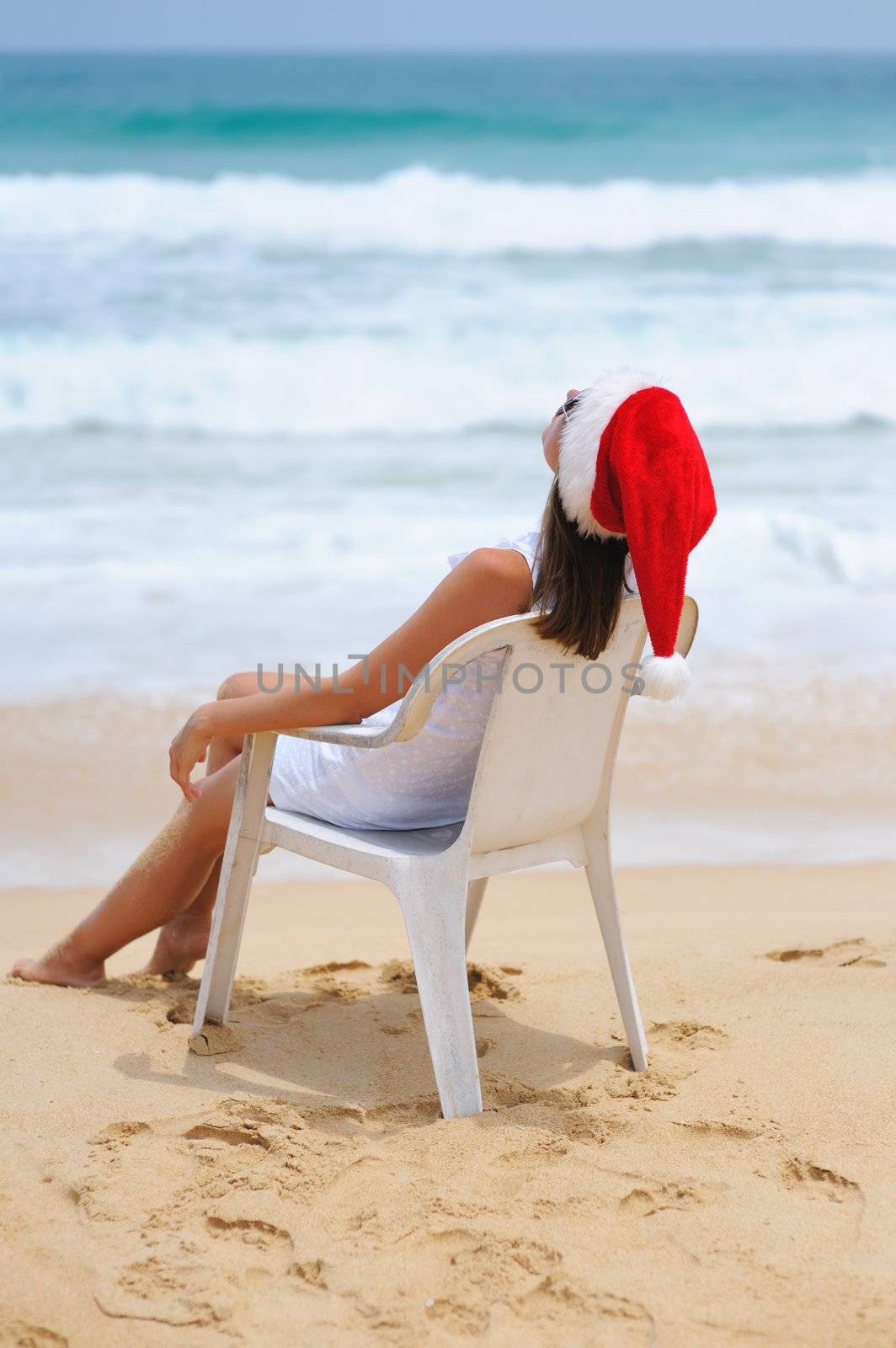 Woman on the beach in santa's hat