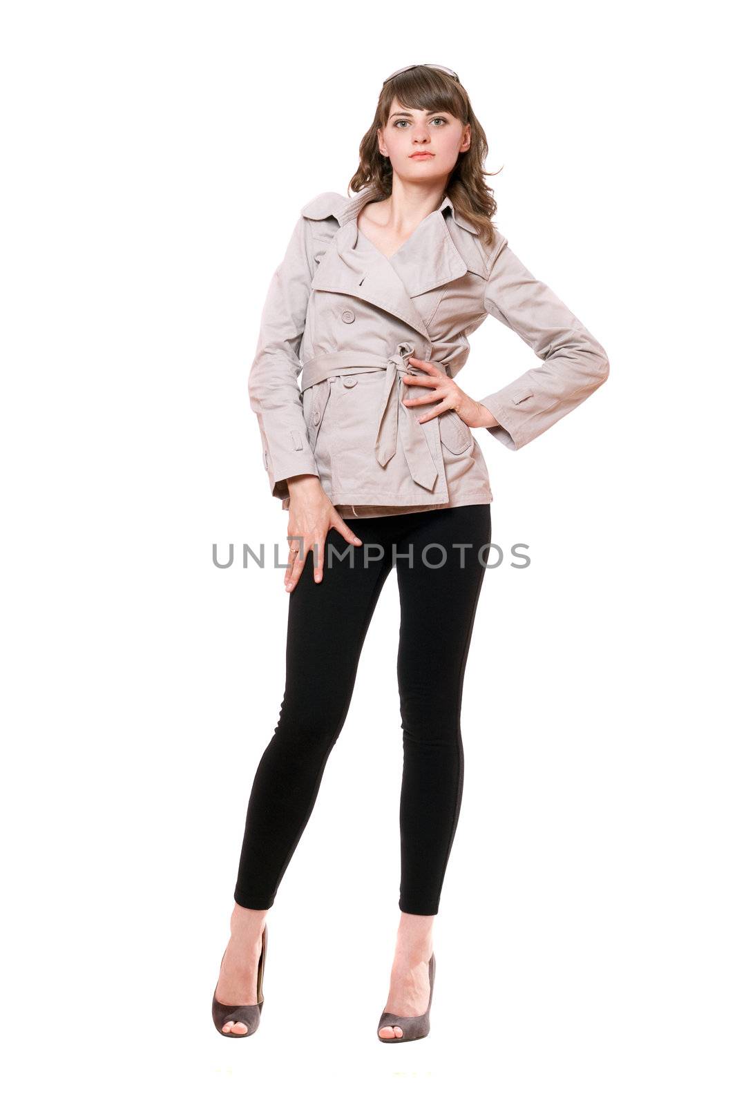 Pretty young woman wearing a coat and black leggings. Isolated