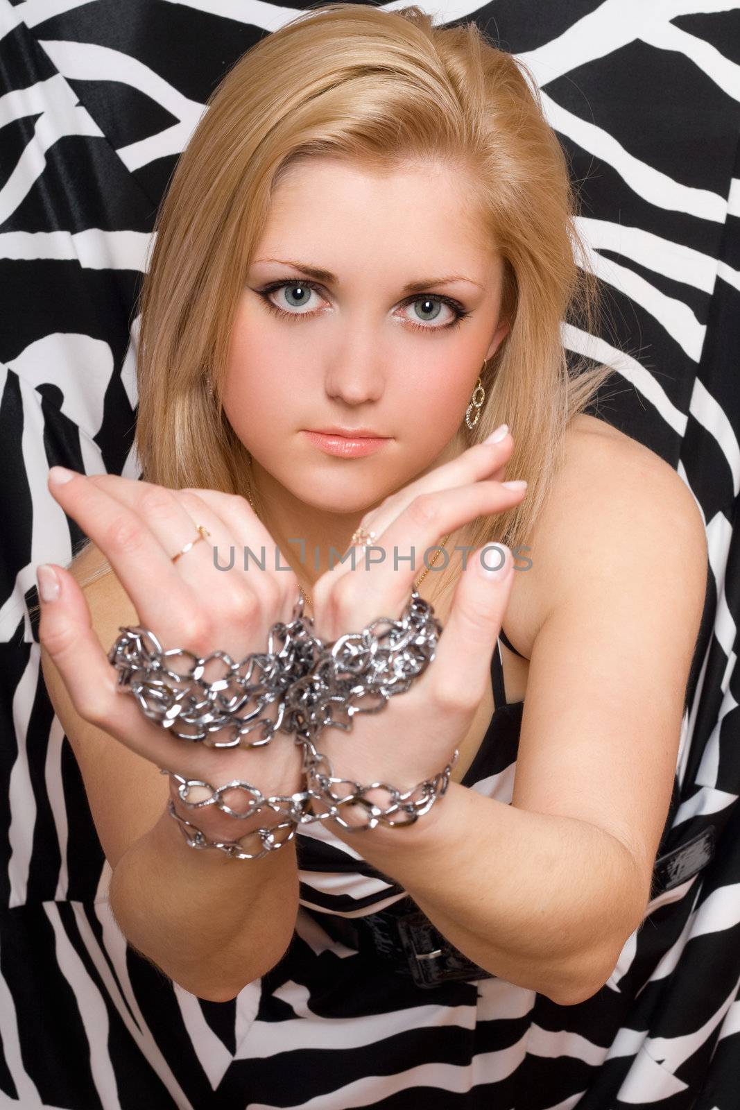Sensual sexy blonde stretches out her hands in chains