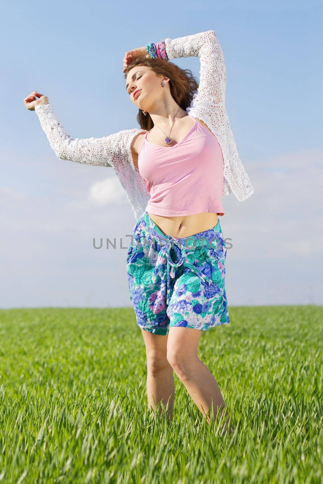 Attractive young woman in a green field