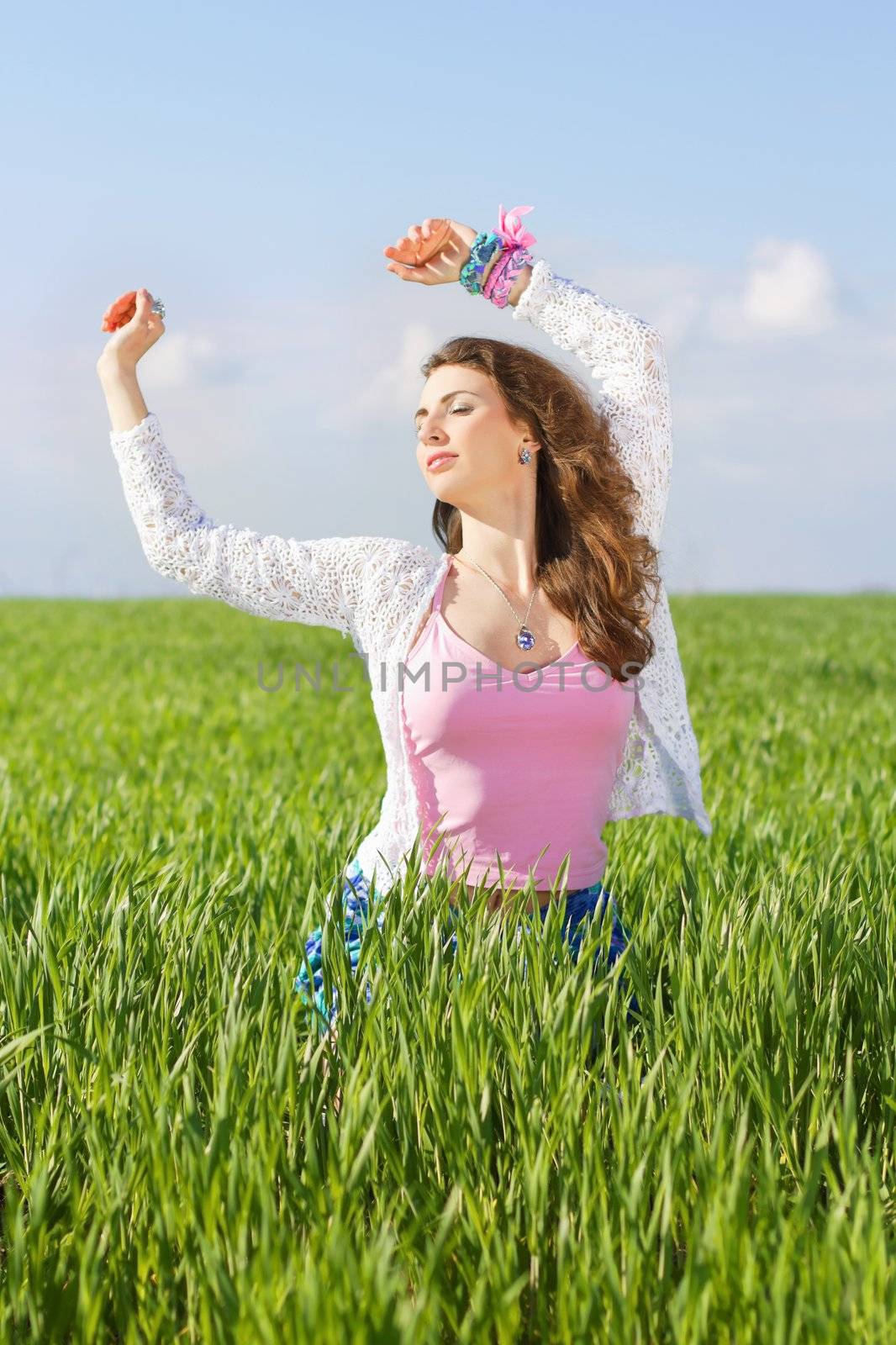 Portrait of nice young woman in a green field