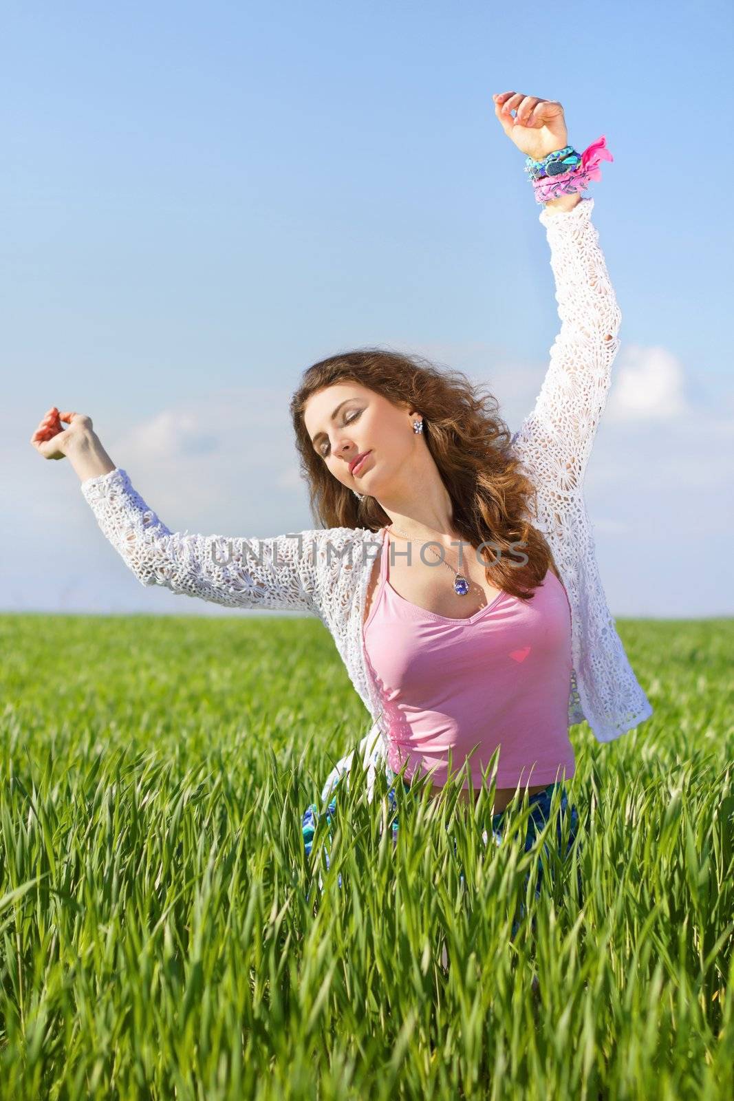 Portrait of attractive young woman in a green field