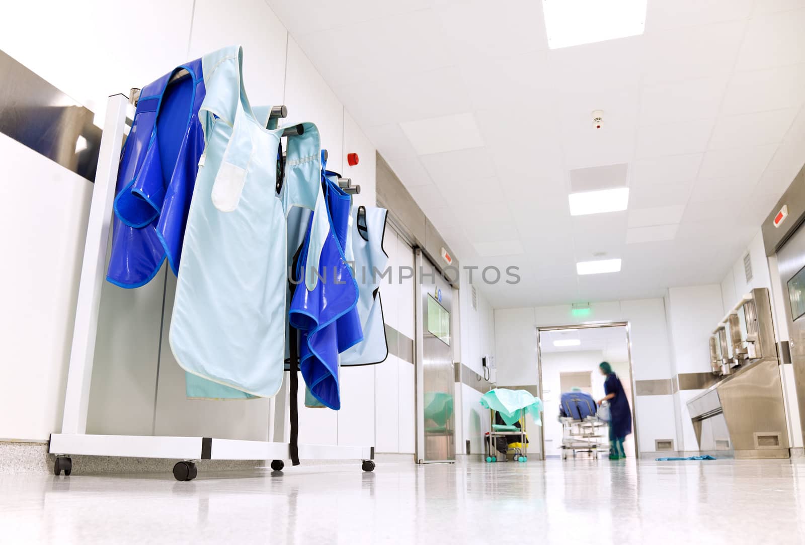 Hospital corridor with doctor protective uniforms by vilevi