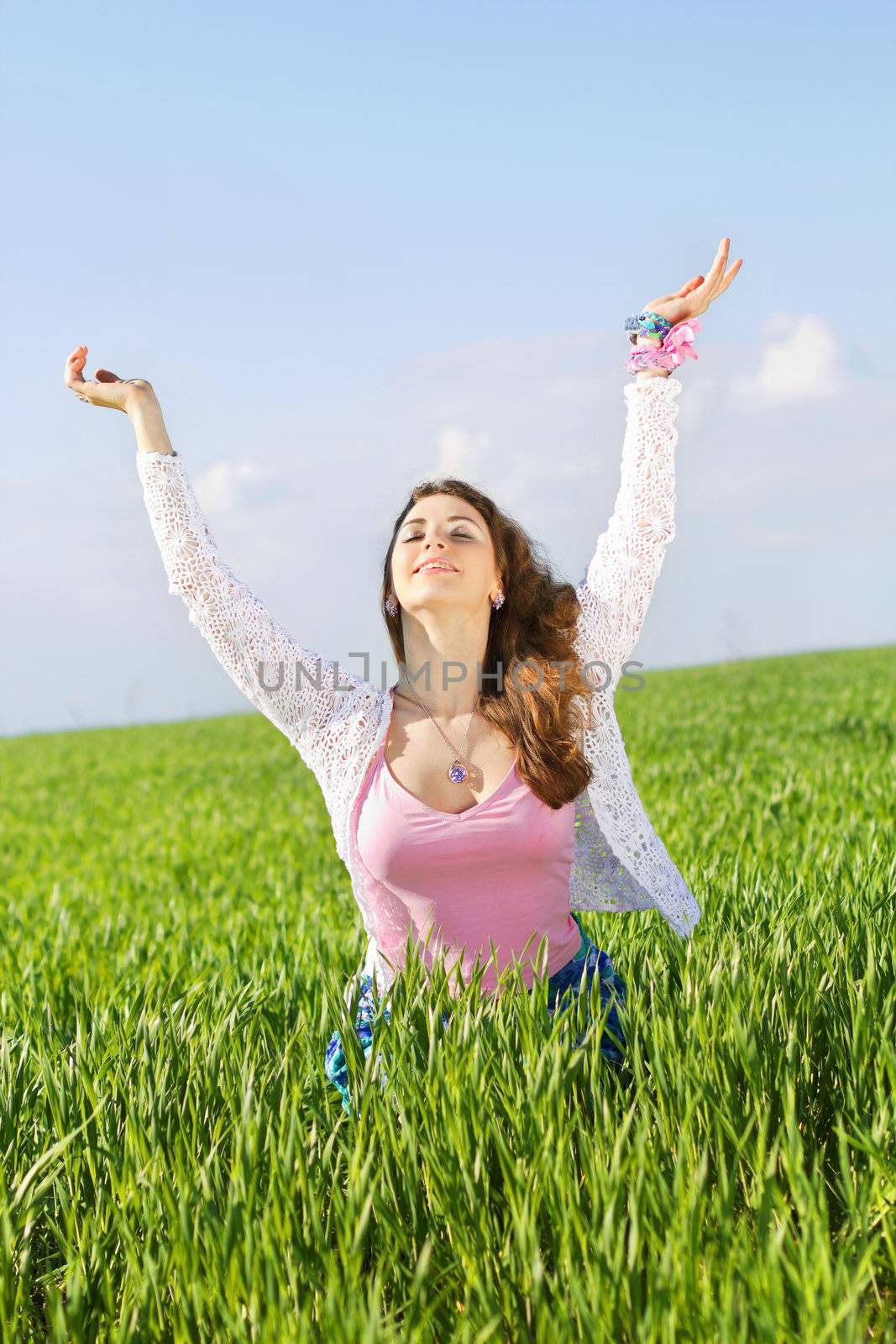 Portrait of happy nice young woman in a green field