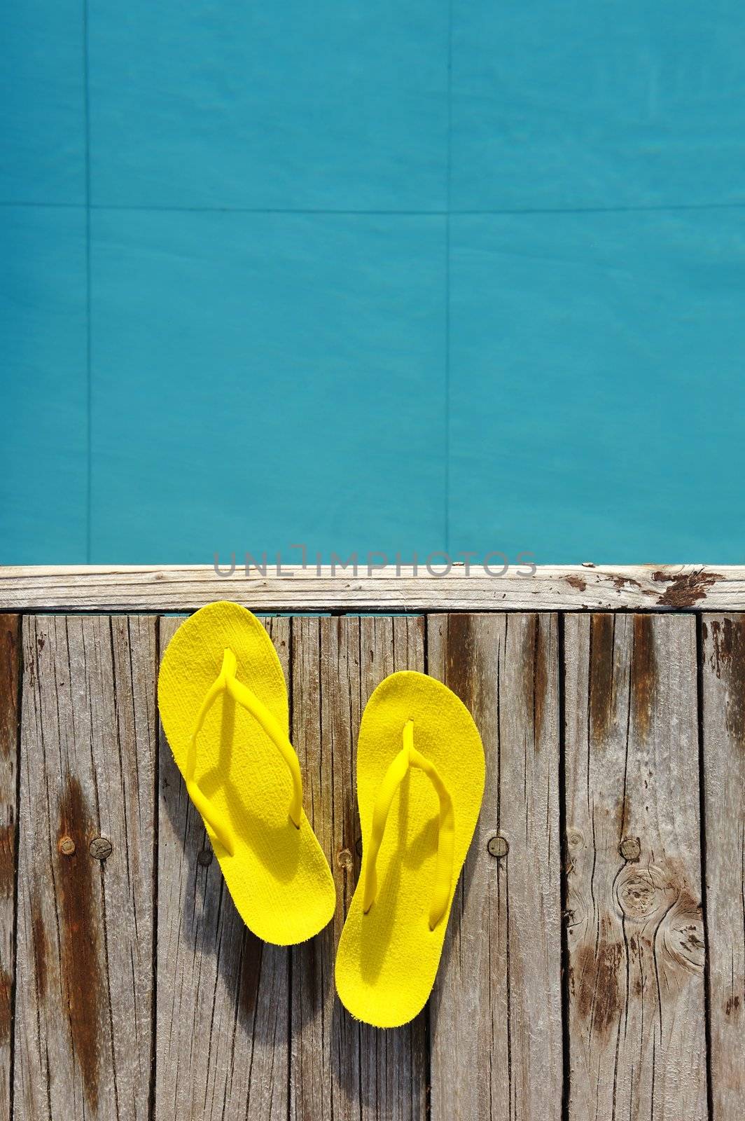 Yellow sandals by a swimming pool 