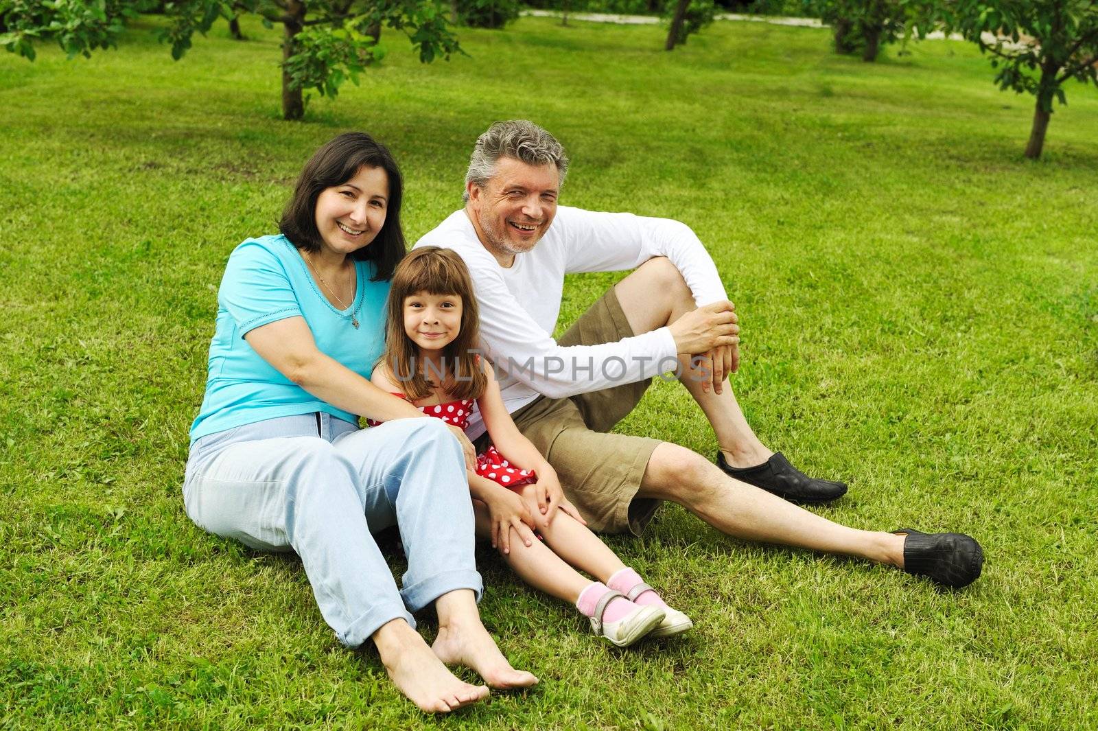 Mature couple with daughter on grass outdoors