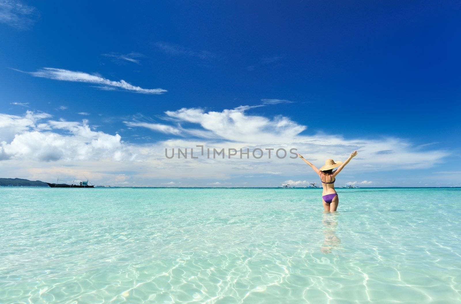 Girl on a tropical beach with outstretched arms