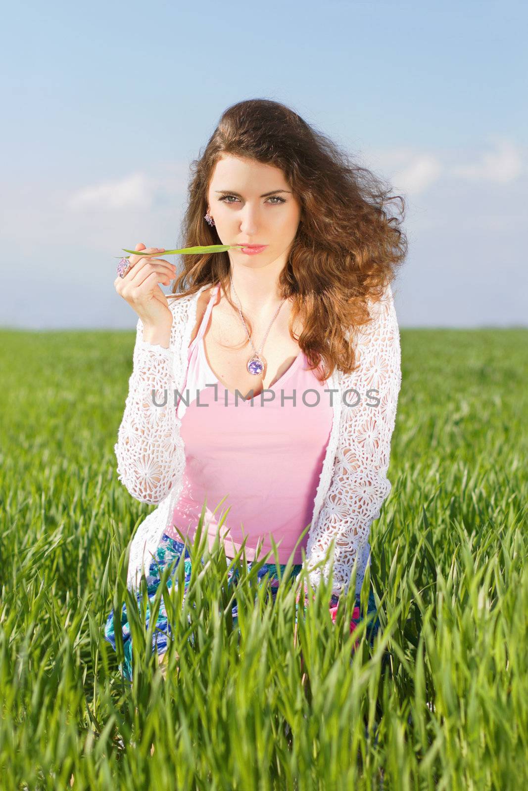 Portrait of serious young woman in a green field