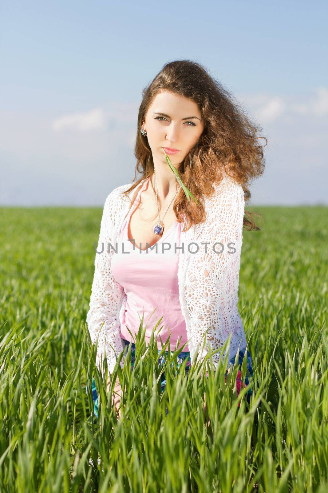 Portrait of gorgeous young woman in a green field