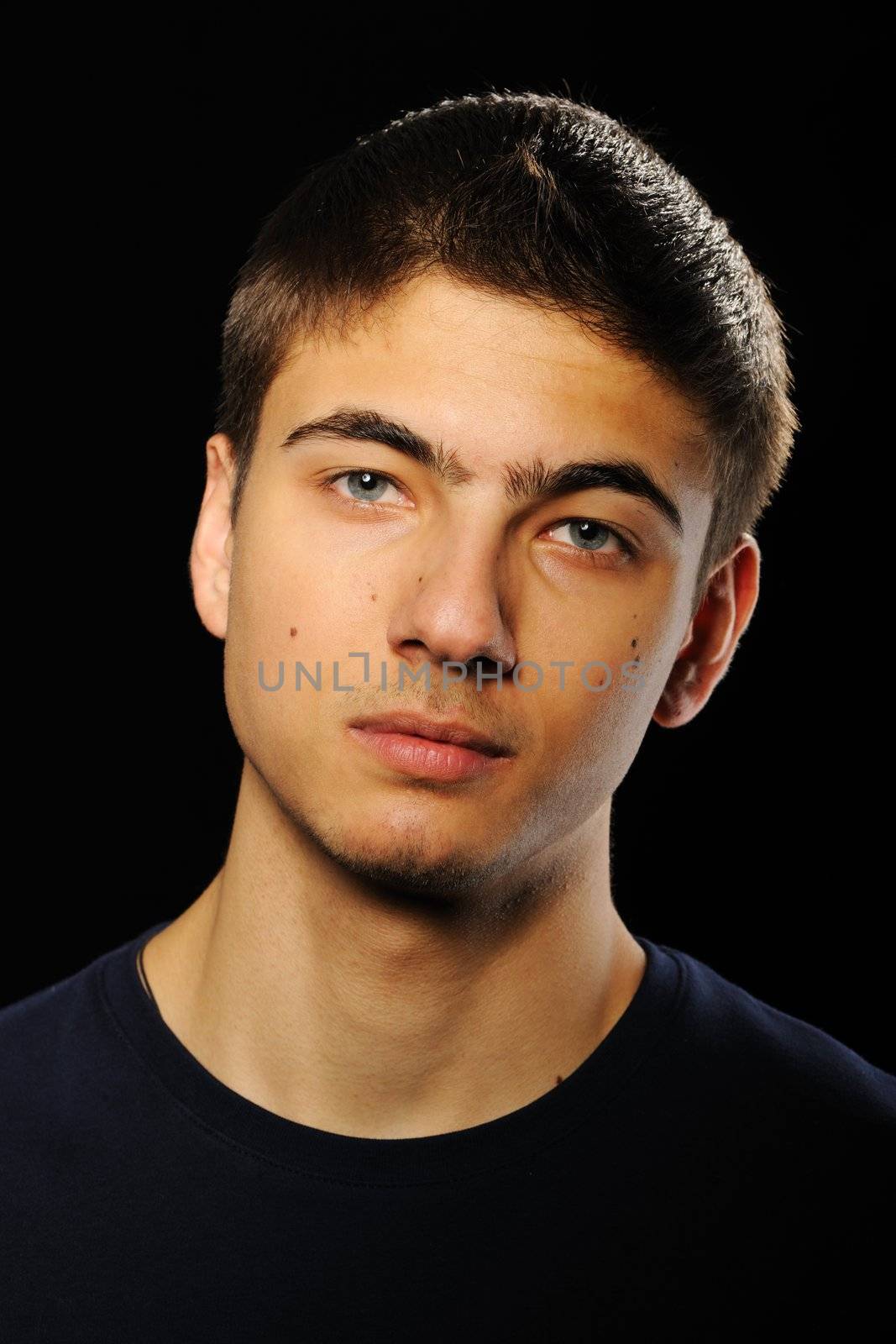 Young man portrait over black background