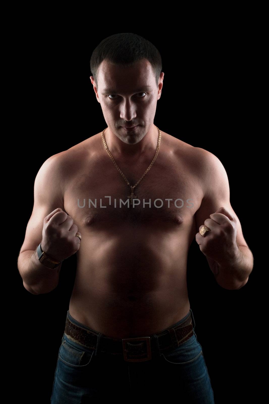 Portrait of a strong young man. Isolated on black