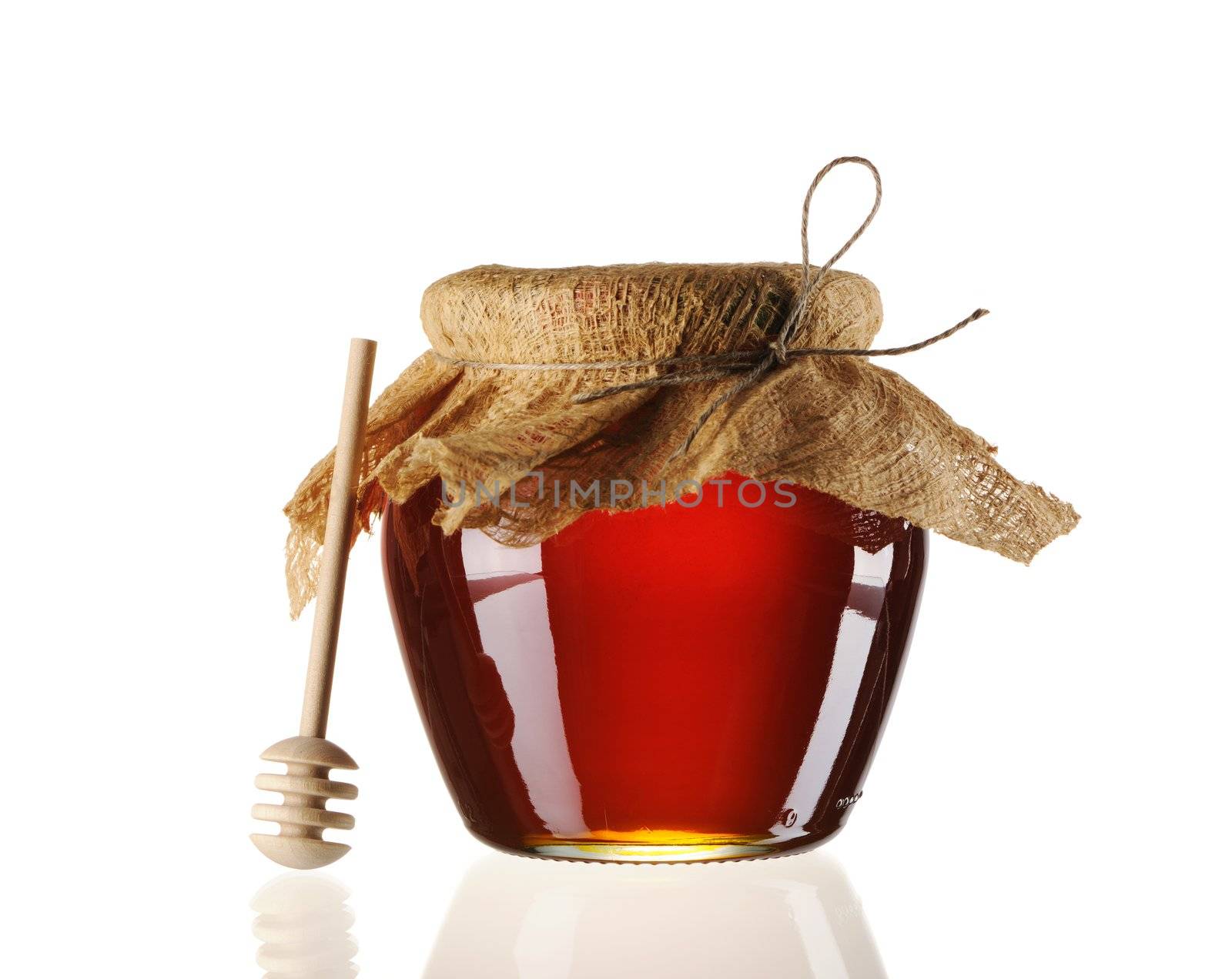Jar of honey and dipper isolated over white
