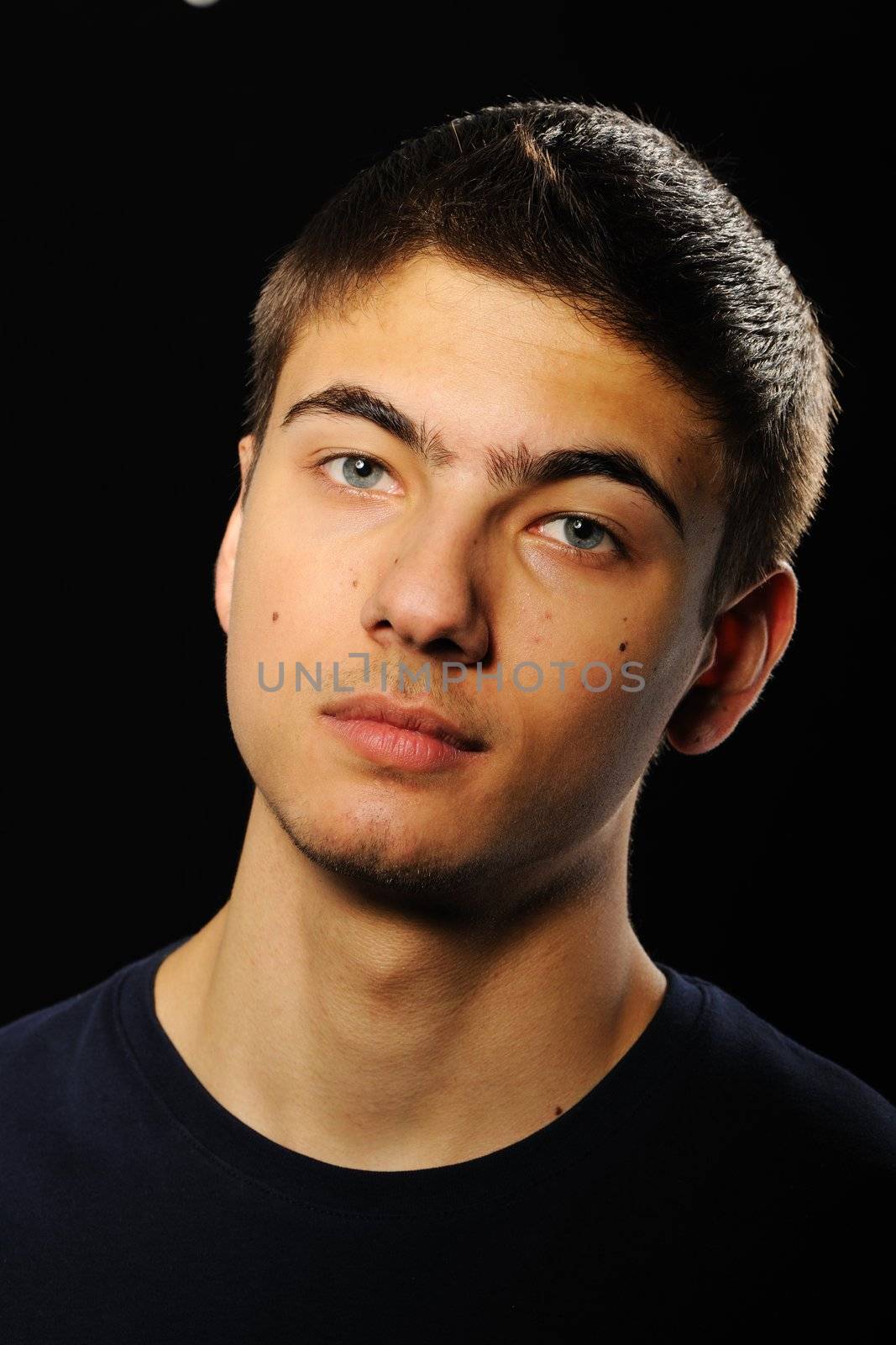 Young man portrait over black background