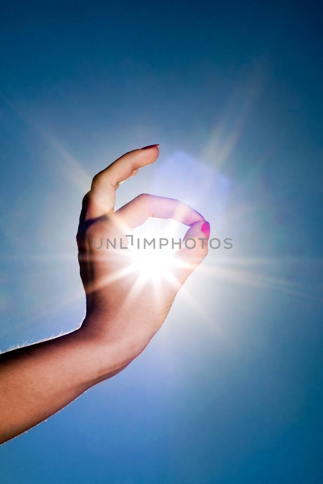 Woman hand around the sun and blue sky