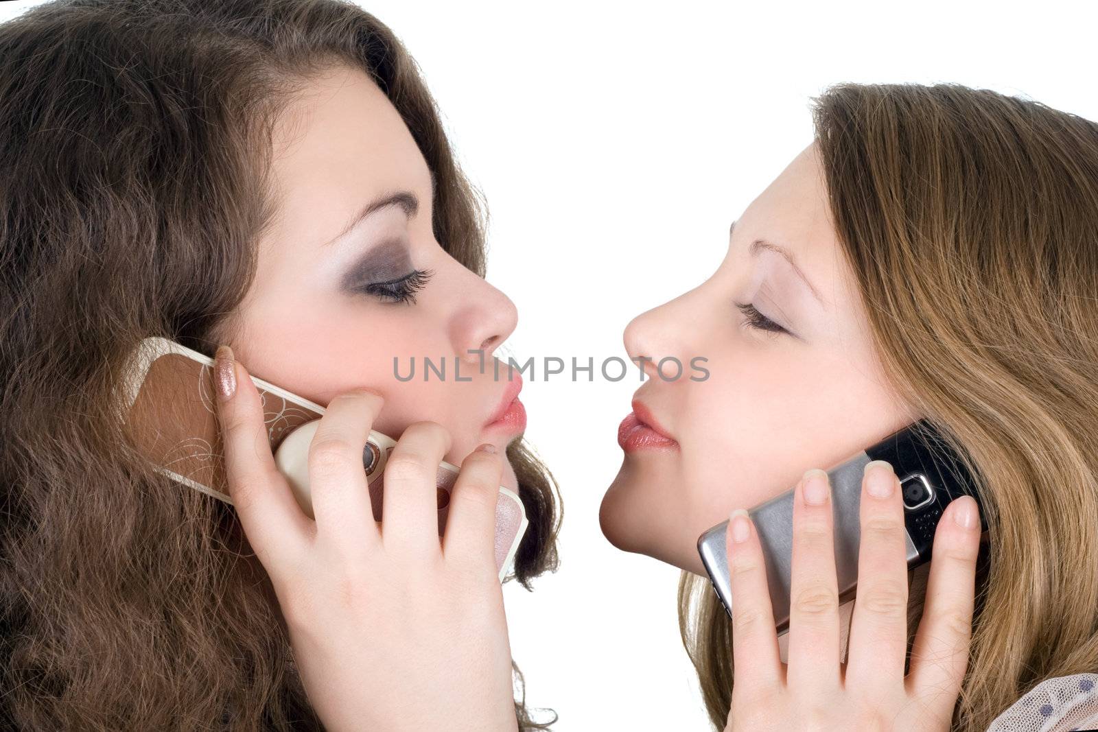 Two beautiful girls with phones. Isolated on white