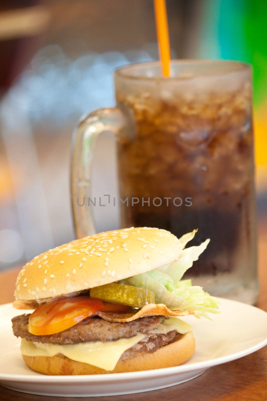 Cheeese beef burger in white plate at a shop with Drinks as background, shallow depth of field