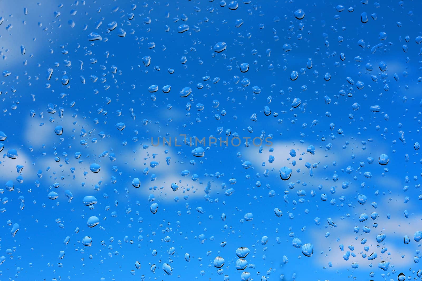 Water drops on glass against the sky