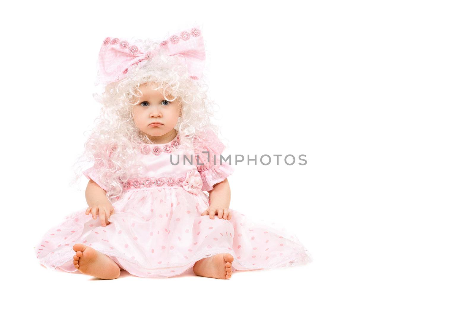 Sad baby girl in a pink dress. Isolated