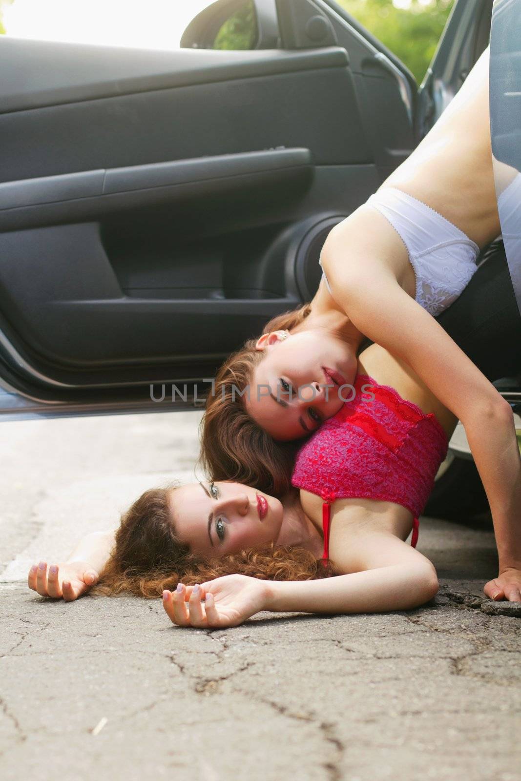 Two sexy young women lying on the road