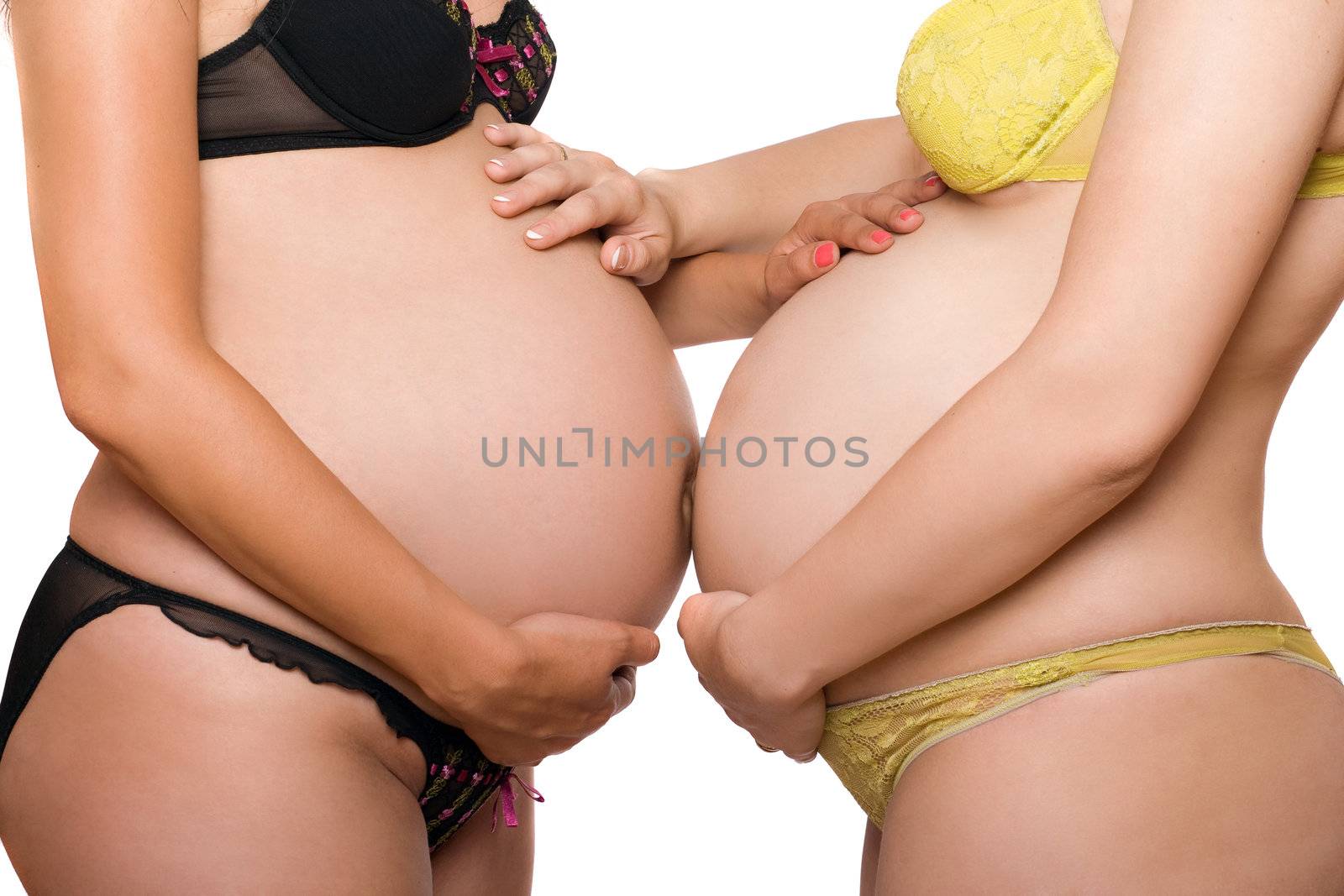 Two bellies of pregnant young women. Isolated on white background