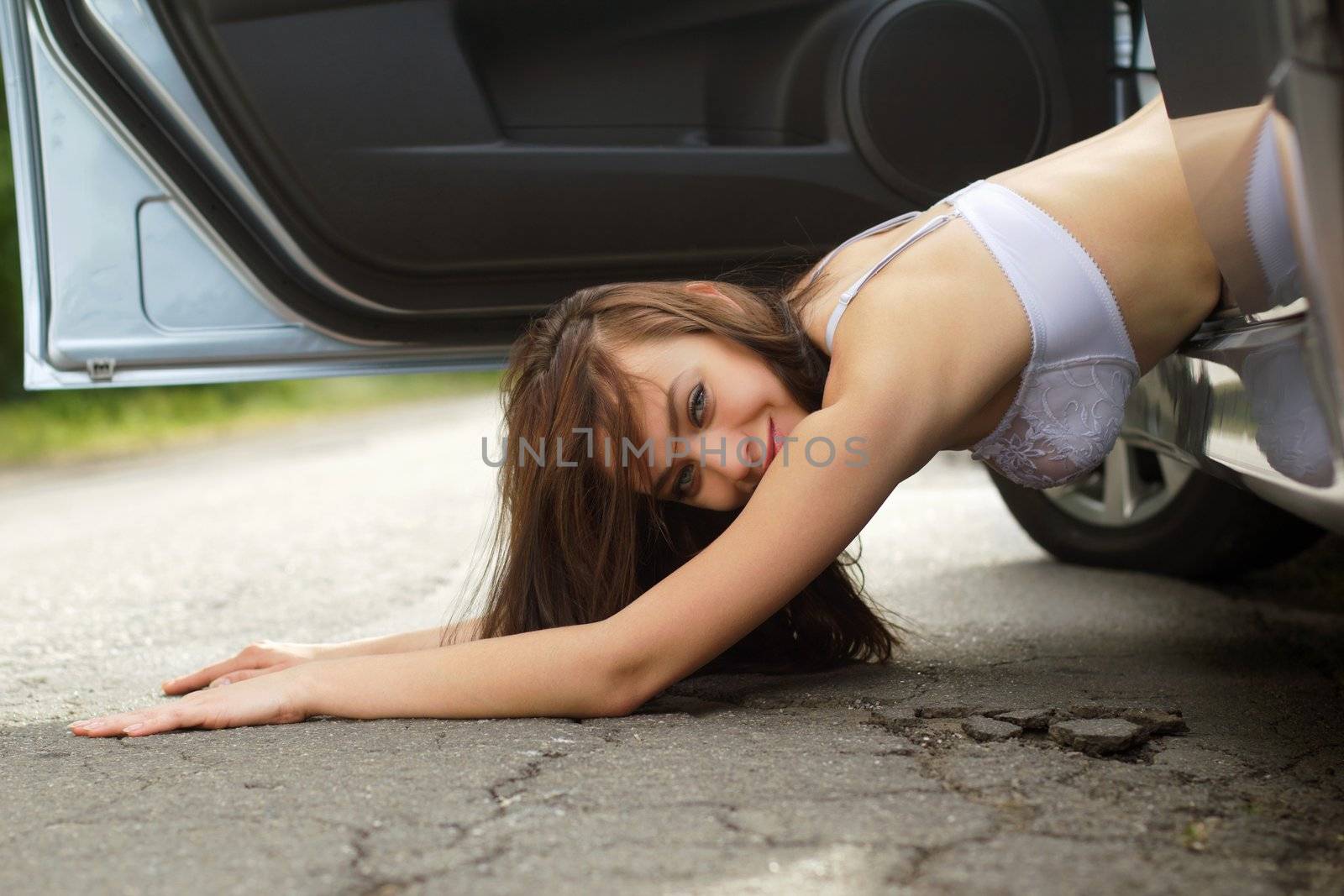 Smiling young woman lying on the road
